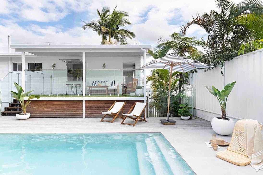 a cottage with a pool in front of it